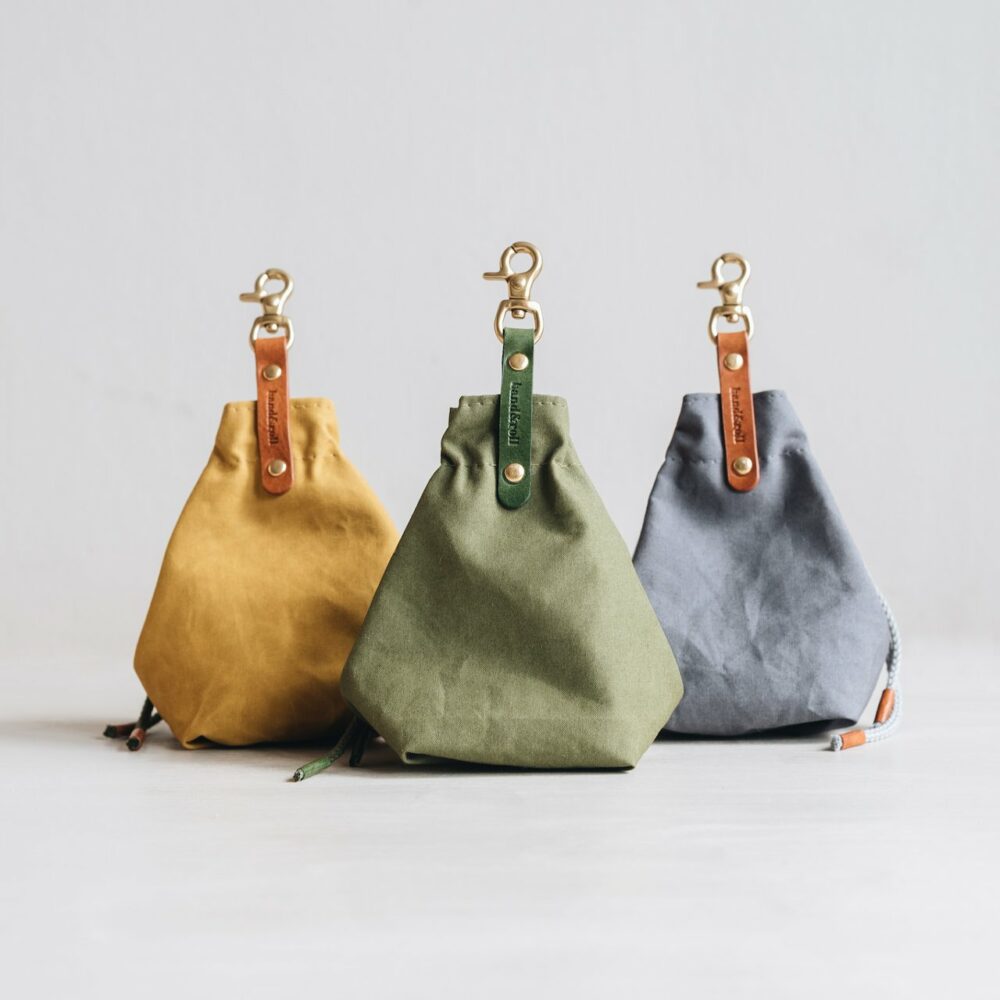 Three dog treat bags in mustard, green and grey by Band & Roll, arranged side by side.