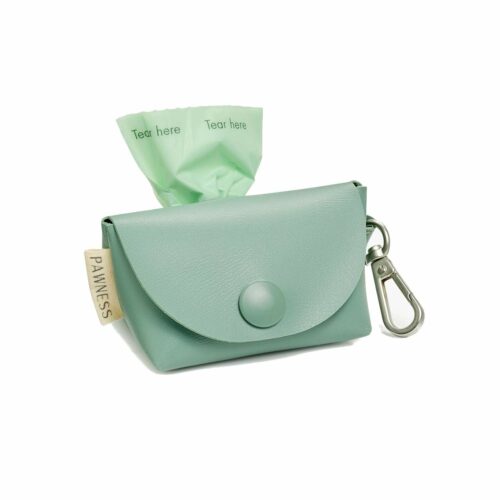 A hand-made poop bag holder made from non-toxic vegan leather in vibrant emerald green color. It features a zipperless front snap closure design and a nickel-free, matt silver snap hook clip for easy attachment to a leash or belt loop. The bag is roomy yet compact and can fit a standard-sized poop bag roll. The back of the bag has a round opening with smooth edges, allowing for quick and easy access to the waste bags without tearing them.