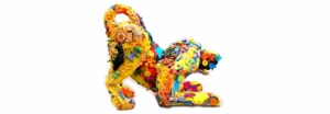 Side view of a dog sculpture in a playful bow pose, crafted from an assemblage of plastic items, showcasing a vibrant mix of colors and textures.